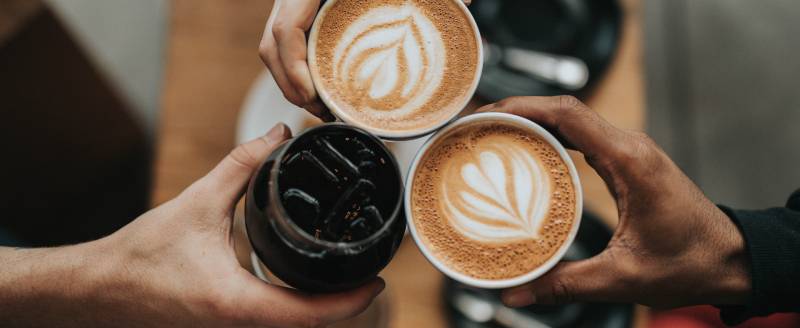 people putting coffee cups together